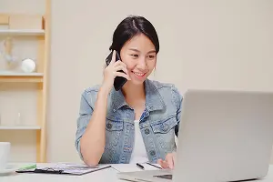 電話で申し込みする女性